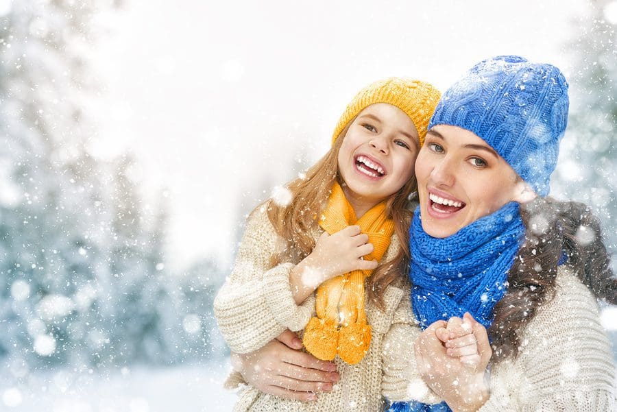 Happy family! Mother and child girl on a winter walk in nature.